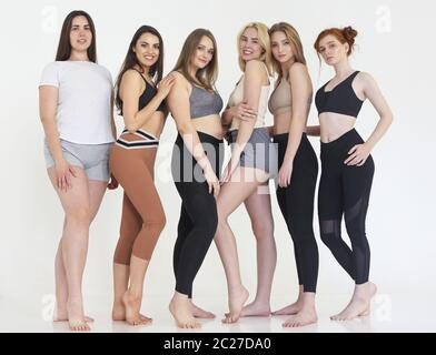 Glückliche Frauen in verschiedenen Rennen tragen Sport-Top und Leggings Stockfoto