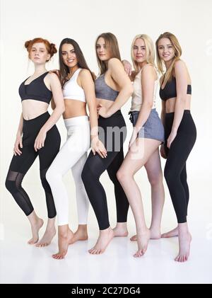 Glückliche Frauen in verschiedenen Rennen tragen Sport-Top und Leggings Stockfoto