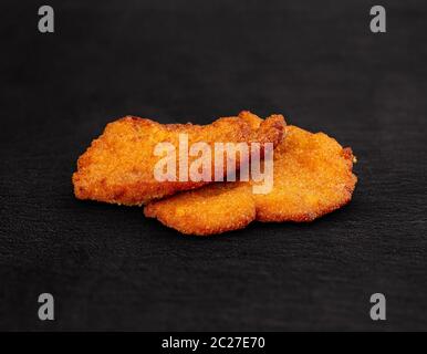 Zwei Huhn paniertes Schnitzel auf schwarzem Hintergrund Stockfoto