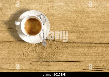 Draufsicht auf eine kleine Tasse Kaffee auf einem Holztisch Stockfoto