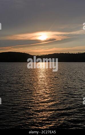 Sonne lauert hinter den Wolken bei Sonnenuntergang am Knife Lake in den Boundary Waters in Minnesota Stockfoto