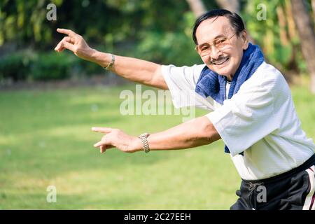 Lächelnder älterer Mann, der Yoga im Garten durchführt Stockfoto