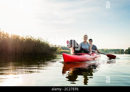 Porträt von Hund und Frau sitzen mit einem Mann Kajak auf idyllischen See Stockfoto