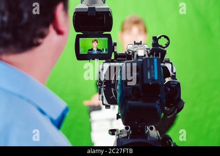 Kamera bei einer Nachrichten Frau oder Reporter in grüne Zimmer Studio, an der Control Monitor erschossen Stockfoto