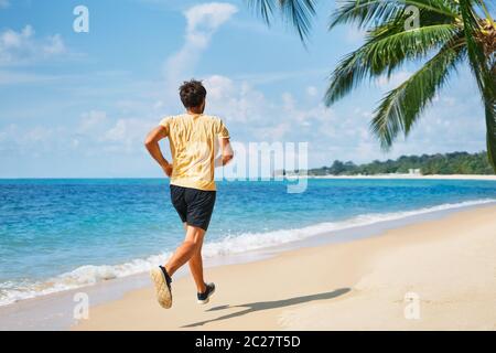 Rückansicht des Laufmanns am tropischen Strand Stockfoto