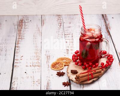 Stillleben mit Früchtetee, Gewürzen und Orangen stehen auf hellem Holzhintergrund mit Kopierraum. Silvester und Weihnachtsgeschenk. Winterurlaub. Stockfoto