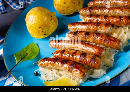 thüringer Bratwurst mit Sauerkraut und Knödel Stockfoto