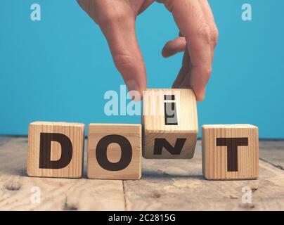 Hand ein Geschäftsmann mit Holzblöcken und die Worte, die es tun! Motivierendes Konzept Stockfoto