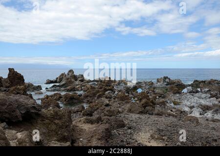 Panoramablick von vulkanogenen Felsen der Barbero Landzunge in Puerto de Santiago in Richtung Gomera Insel, Teneriffa, Kanarische Inseln, Spanien. Stockfoto