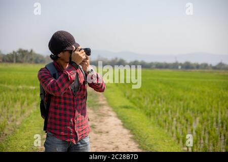 Asian Mann Tourist ist mit einer Kamera für die Aufnahme von Bildern von Landschaft und Berg.Relax Zeit auf Urlaub Konzept Reise Stockfoto