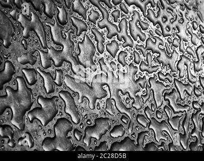 Wasser aus Regen auf einer Stahloberfläche, die ein abstraktes Hintergrundmuster macht Stockfoto