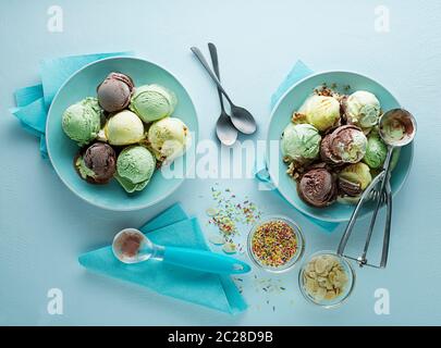 Vielzahl von Eis Schaufeln mit Schokolade Vanille und fruchtigen Geschmack in der Platte mit Utensilien geschaufelt Stockfoto