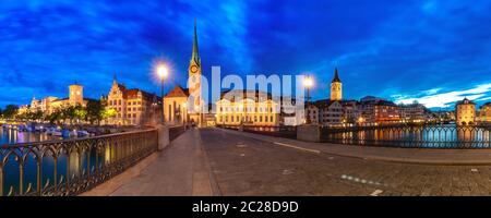 Panorama-Nachtansicht der Fraumünster Kirche und der Münsterbrücke über die Limmat in der Zürcher Altstadt, der grössten Stadt der Schweiz Stockfoto