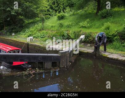 Eine Frau, die ein Schleusentor am rochdale Kanal in hebden Brücke West yorkshire öffnet Stockfoto