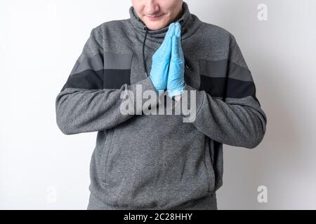 Kaukasischer Mann in blauen Handschuhen auf einem isolierten Hintergrund lächelt und hält Handflächen zusammen Stockfoto