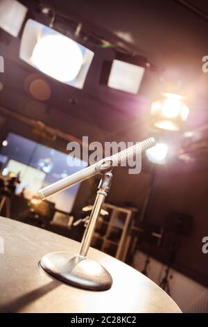 Mikrofon im Aufnahmestudio, Ausstattung und Beleuchtung im verschwommenen Hintergrund Stockfoto