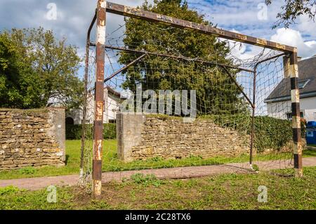 Rusty Fußballtor ein wenig eingerostet auf einem Rasen vor einer Wand in der Region Virton in Belgien Stockfoto