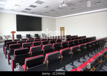 Rote Sitzreihen in einem leeren Raum für Präsentationen, Pressekonferenzen und Seminare Stockfoto