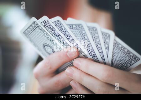 Spielkarten: Poker-Karten in der Hand eines jungen Mannes Stockfoto