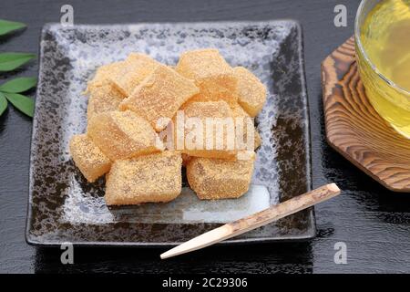 Japanische Süßwaren, Warabi mochi traditionellen Süßigkeiten auf schwarzem Hintergrund Stockfoto