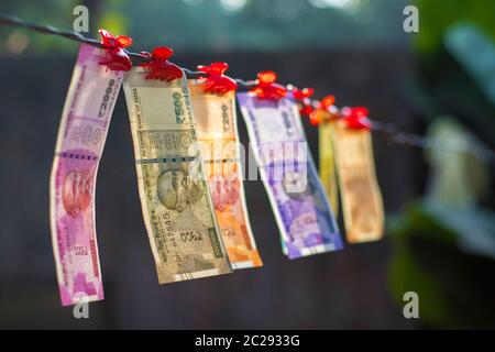 Selektiver Fokus der neuen indischen Banknoten Rupien zehn, zwanzig, fünfzig hundert, zweihundert, fünfhundert und zwei Tausend hängen in einem Kabel. Stockfoto