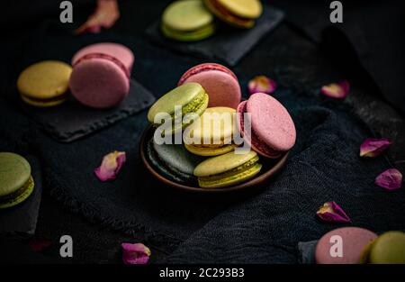 Bunte französische oder italienische Macaron Stapel auf Holzplatte, dunkler Hintergrund Stockfoto