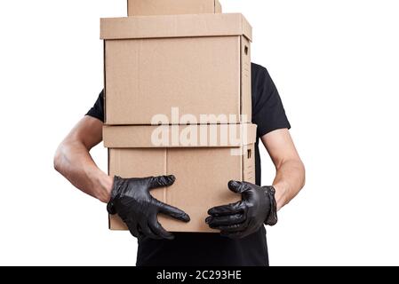 Lieferung Mann in schwarzer Uniform mit medizinischen Handschuhen und Schutzmaske halten Pappkarton, isolieren. Kontaktloses Lieferdienstkonzept Stockfoto