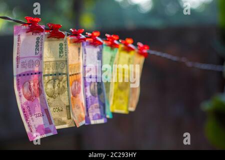 Selektiver Fokus der neuen indischen Banknoten Rupien zehn, zwanzig, fünfzig hundert, zweihundert, fünfhundert und zwei Tausend hängen in einem Kabel. Stockfoto
