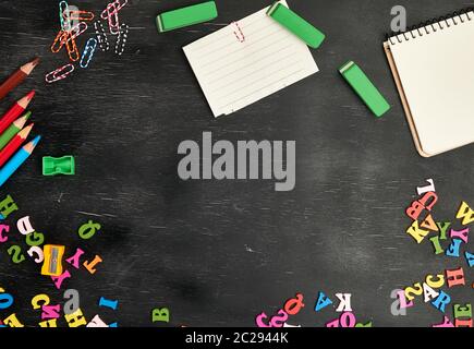 Schulmaterial: Bunte Bleistifte aus Holz, Notebook, Papier, Aufkleber, Büroklammern, Bleistiftspitzer, Kopieren, flach Stockfoto