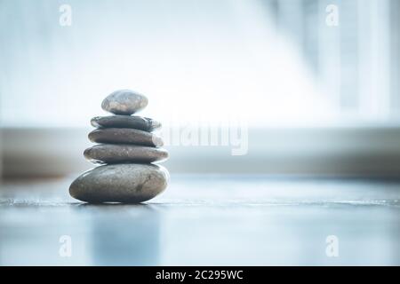 Feng Shui: Zen-Steine auf dem Holzboden kommt helles Licht durch das Fenster Stockfoto