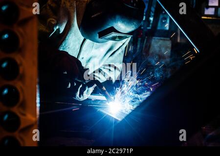 Schweißgerät arbeiten im Werk mit vielen Funken fliegen Stockfoto