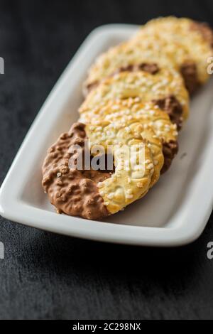 Kekse und ähnliches Kleingebäck, gesüßt Ringe. Kekse mit Schokolade an der Platte. Stockfoto