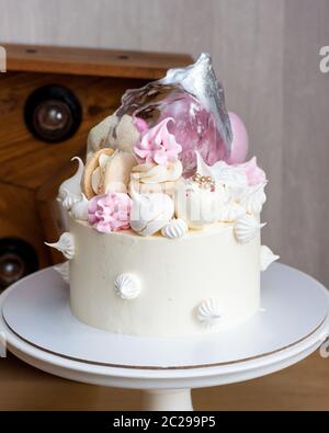 Eleganter weißer Kuchen mit Isomalt, Schokolade, Makronen, Baisalgen, Rosa und Silber Elementen. Stockfoto