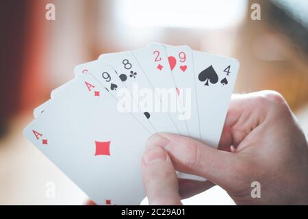 Spielkarten: Poker-Karten in der Hand eines jungen Mannes Stockfoto