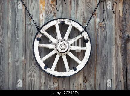 Alte Karre Rad hängen an vintage Holzwand. Stockfoto