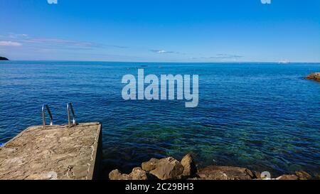 Felsiger Strand, bue transparentes Meer in Istrien, kroatische Küste Stockfoto