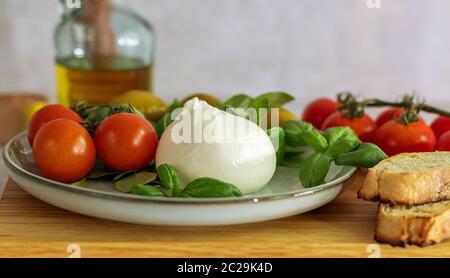 Frischer italienischer Burrata-Käse mit Tomaten, Basilikum und Oliven. Stockfoto