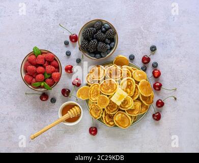 Schüssel mit Cerealien winzig Pfannkuchen mit Beeren und Ahornsirup. Stockfoto
