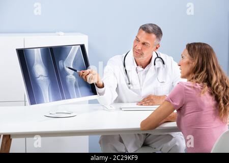 Arzt, Knie X-ray zu Patienten auf dem Bildschirm Stockfoto