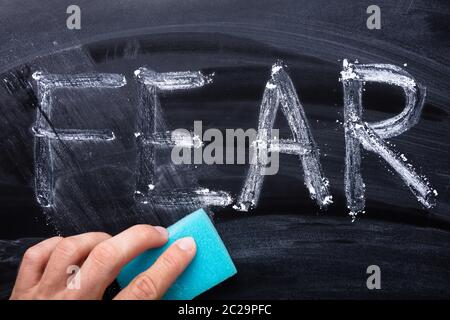 In der Nähe von Hand löschen Angst Wort mit blauen Schwamm auf Blackboard Stockfoto