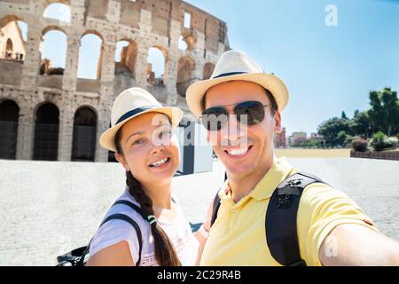 Paar unter Selfie Vor dem Kolosseum, Rom, Italien Stockfoto