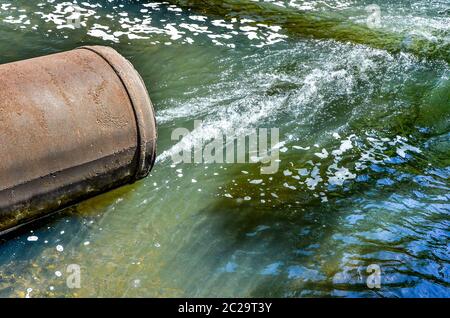 Fließt das Wasser aus der Leitung in den Fluss. Stockfoto