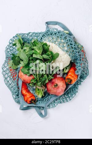 Flatlay von Null Abfall nachhaltige Lebensmittel einkaufen, verschiedene Früchte, Gemüse und Gemüse in einem blauen Netzbeutel Stockfoto