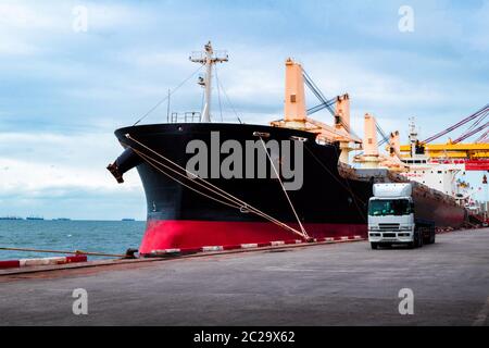 Große Bulk-Frachtschiff Liegeplatz am Hafen Entladen Fracht. LKW verlässt Terminal nach dem Laden der Ladung. Stockfoto