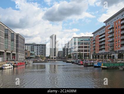 Ein Blick auf leeds Dock mit modernen Wohnanlagen und Bars mit festledernen Hausbooten und blau bewölktem Himmel Stockfoto