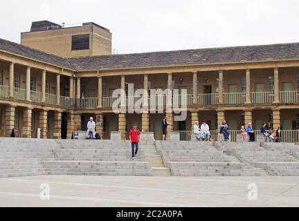 Menschen gingen und saßen auf den Stufen der Stuck Hall in halifax West yorkshire Stockfoto