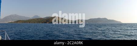 Landschaftlich schöne Panoramasicht auf die Südseite der Fethiye Bucht mit Vergnügungsyachten im Licht des Sommeruntergangs, Türkei. Stockfoto