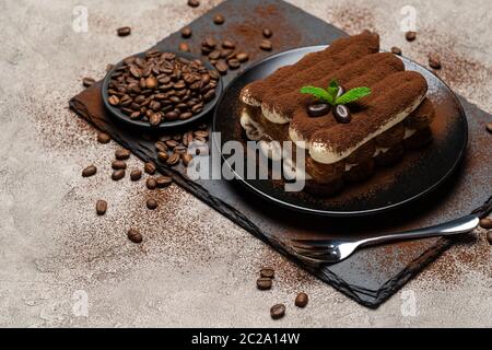 Klassisches Tiramisu Dessert auf Keramikplatte auf Betongrund Stockfoto