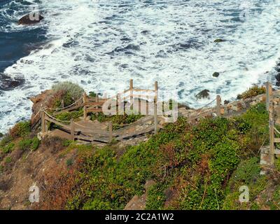 Eine steile Holztreppe schlängelt sich über eine steile Küste zu einem romantischen Badestrand in Benijo im Anaga-Gebirge auf der Kanarischen Insel Ten Stockfoto