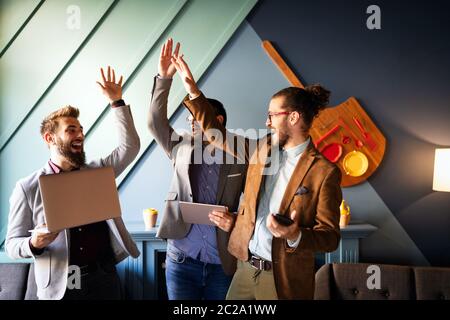 Glücklich erfolgreichen Geschäftsmann geben eine hohe Fünfer Geste als jubeln ihren Erfolg Stockfoto